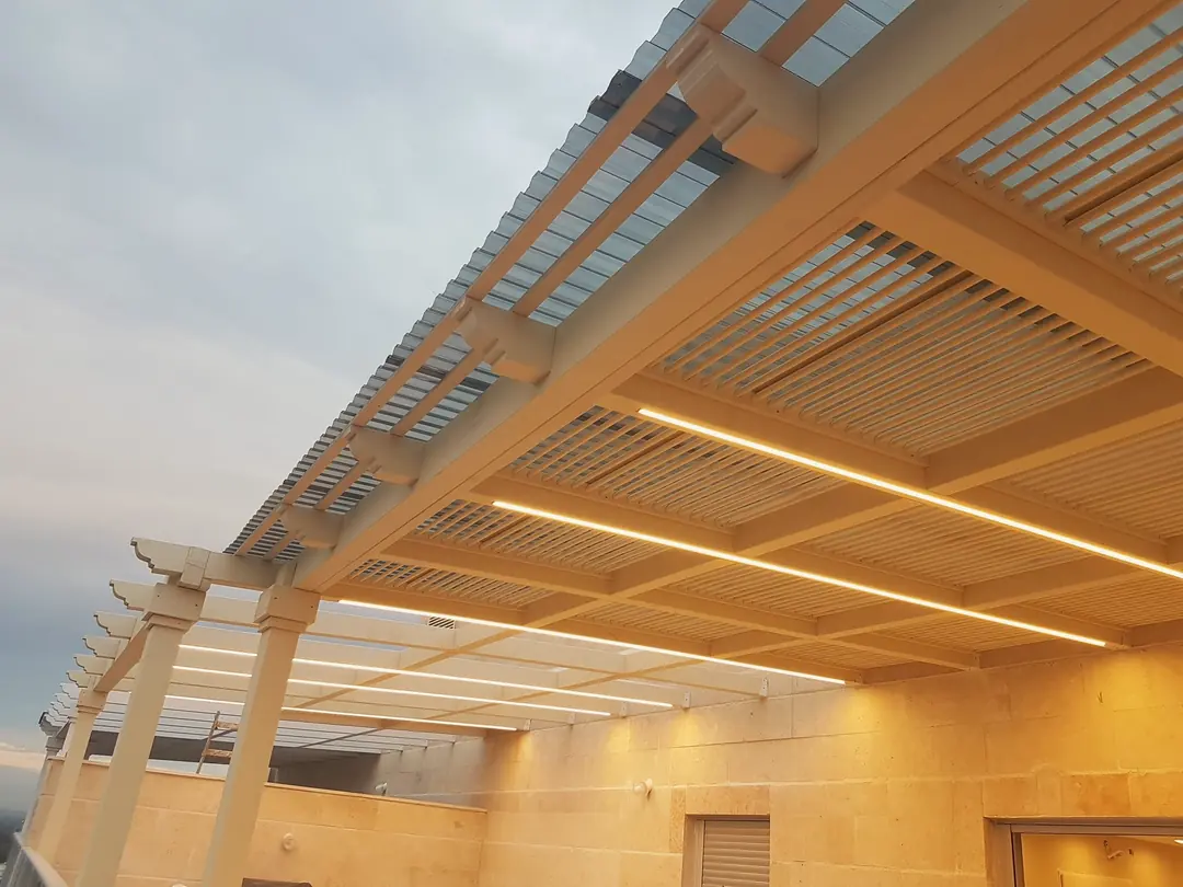 Пергола на крыше с горящими LED-линиями вечером, стена из иерусалимского камня